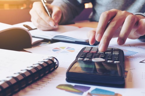 Hand man doing finances and calculate on desk about cost at home office.